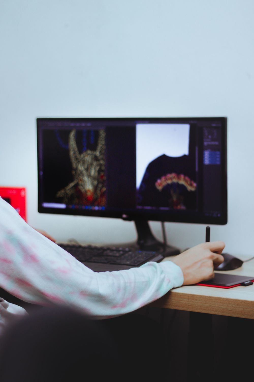 Designer redrawing artwork on a computer with a stylus